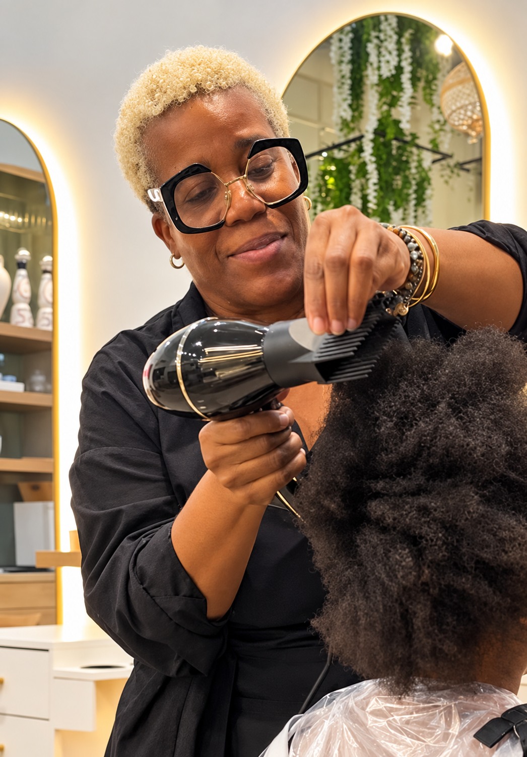 Mrs. Marva working on a client’s hair